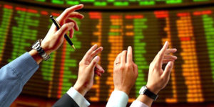 Hands pointing to stock trading board