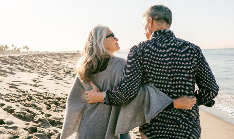 Older aged couple walking on beach